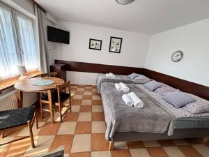 a bedroom with a bed and a table in it at Kwatery u Szymka in Jastarnia