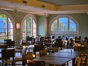 ein Restaurant mit Tischen, Stühlen und Fenstern in der Unterkunft Hotel Funicolare in Lanzo dʼIntelvi + 19 Fotos