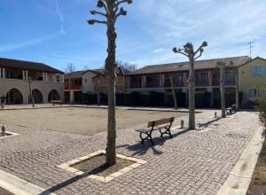 a park bench in a courtyard with three trees at Bienvenue confort et quietude vous attendent in Monflanquin
