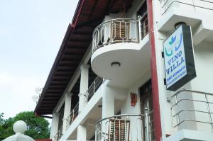a white building with balconies and a sign on it at vino villa in Kandy