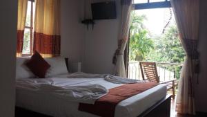 a bedroom with a bed in front of a window at vino villa in Kandy +1 photo