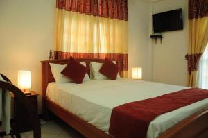 a bedroom with a large bed with two pillows at vino villa in Kandy