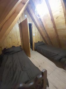 a room with two beds in a attic at Cabañas EL ÁNGEL DE JOSÉ in Eva Perón
