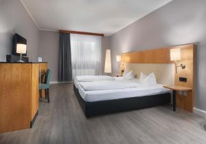 ein Hotelzimmer mit einem Bett und einem Fernseher in der Unterkunft Trip Inn Hotel Egelsbach Frankfurt in Egelsbach