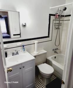 a bathroom with a toilet and a sink and a tub at Cozy 1 Bedroom Business Suite in Philadelphia