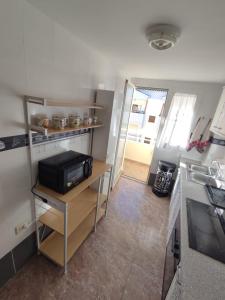 a small kitchen with a counter and a microwave at Relax on Miramar Beach in Miramar