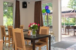 un comedor con una mesa con flores y globos en Karkle Beach Apartments, en Karklė
