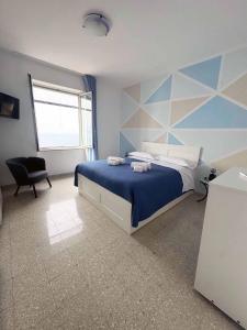 a bedroom with a bed with a blue and white wall at Ambra Holiday House in Furore