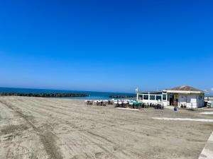 a building on the beach with tables and chairs at Casa Romano SeaFront in Fiumicino +13 photos