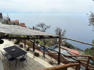 a patio with a table and chairs and the ocean at Ambra Holiday House in Furore