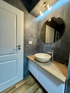 Un baño con un lavabo y un espejo. en Elite Center Apartment, en Oradea 30 fotos más