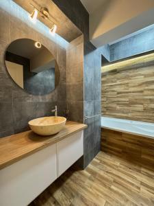 Un baño con lavabo y bañera. en Elite Center Apartment, en Oradea