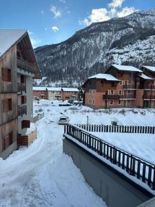 a snow covered town with buildings and a mountain at le petit sport 2 in La Salle-les-Alpes
