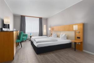 a hotel room with a bed and a table and chairs at Trip Inn Hotel Egelsbach Frankfurt in Egelsbach +34 photos