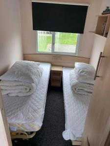 two beds in a small room with a window at Caravan getaway sand le mere tunstall in Hull