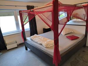 a bedroom with two bunk beds with red drapes at Pension Mühlental Hüllhorst in Hüllhorst