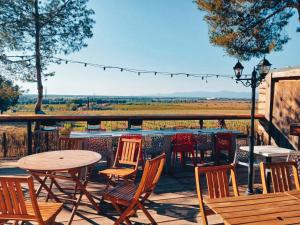 a patio with tables and chairs and a view of a field at Camping Le Bois De Pins in Salses-le-Chateau