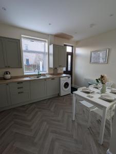 Una cocina con una mesa, un fregadero y una estufa. en Hilltop Retreat at Banktop, en Southowram