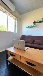Una computadora portátil sobre una mesa de madera en una sala de estar. en Saint Saus - Casa en Sauce de Portezuelo, Maldonado, en Maldonado