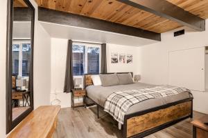 a bedroom with a bed and a desk and windows at Snow Valley Retreat With Spa in Running Springs