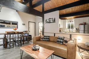 a living room and kitchen with a couch and a table at Snow Valley Retreat With Spa in Running Springs
