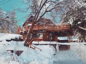 a log cabin in the snow with snow on the ground at Snow Valley Retreat With Spa in Running Springs