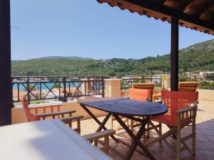 a table and chairs on a patio with a view of the ocean at TOBY's HOUSE in Poseidónion