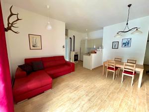 a living room with a red couch and a table at Appartamento Cuore D’Abruzzo in Scanno