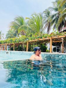 een man in het zwembad in een resort bij Hotel Playa Tiburón in Coveñitas