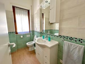 ein Badezimmer mit einem weißen Waschbecken und einer Toilette in der Unterkunft Appartamento Cuore D’Abruzzo in Scanno