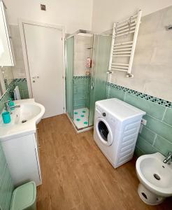ein Badezimmer mit Waschmaschine und Waschbecken in der Unterkunft Appartamento Cuore D’Abruzzo in Scanno