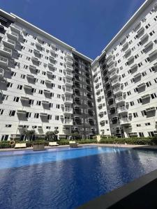 マニラにあるCharm Residences Staycation by Ashtiの大きなスイミングプール付きの2棟の大きなアパートメントです。
