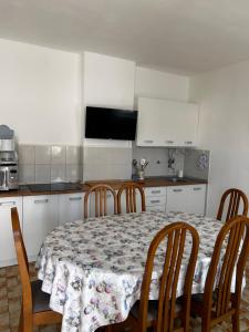 una cocina con mesa y sillas y una cocina con armarios blancos. en Apartments Ana Malinska island Krk, en Vantačići