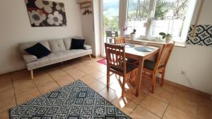a living room with a table and chairs and a couch at Ferienwohnung im Moselland in Maring-Noviand