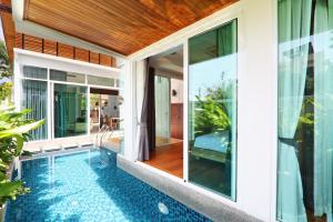 an external view of a house with a swimming pool at Villa Alia in Rawai Beach
