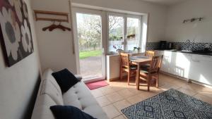 a living room with a couch and a table and a kitchen at Ferienwohnung im Moselland in Maring-Noviand