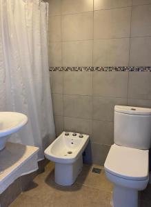 a bathroom with a white toilet and a sink at Vista Linda in Mar del Plata +8 photos