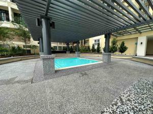 a swimming pool in a building with awning at Wind Homestay Riverine Diamond in Kuching