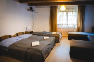 a hotel room with two beds and a window at Tömördi Vendégház in Tömörd