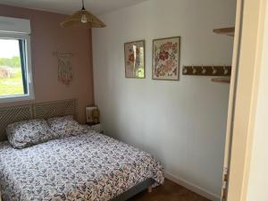 ein Schlafzimmer mit einem Bett und zwei Bildern an der Wand in der Unterkunft Maison de campagne proche 24h in Roézé-sur-Sarthe