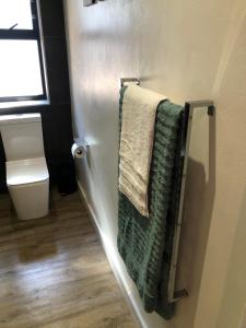 a bathroom with green towels hanging on a wall at Modern, Comfy Guest Suite with Beautiful Views in Tygerberg Hills