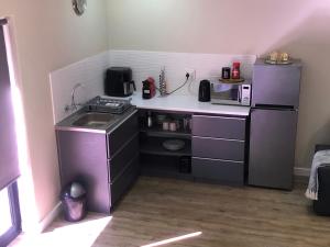 a small kitchen with a sink and a refrigerator at Modern, Comfy Guest Suite with Beautiful Views in Tygerberg Hills
