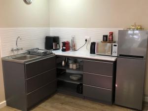 a kitchen with a sink and a refrigerator at Modern, Comfy Guest Suite with Beautiful Views in Tygerberg Hills