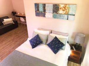 a living room with a bed with pillows on it at Modern, Comfy Guest Suite with Beautiful Views in Tygerberg Hills