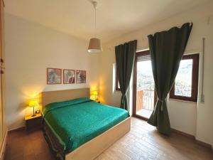 ein Schlafzimmer mit einem grünen Bett und einem Fenster in der Unterkunft Appartamento Cuore D’Abruzzo in Scanno