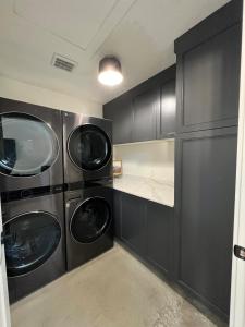 a laundry room with three washer and dryer machines at Yuba Lake Barndominium Resort in Levan
