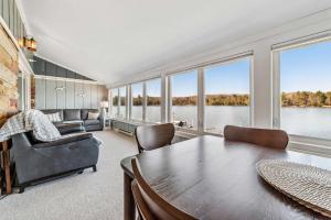 a large living room with a table and chairs and windows at Condo with Panoramic views on Clam Lake in Bellaire