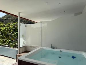 una grande vasca da bagno in una stanza con finestra di Positano Art Hotel Pasitea a Positano