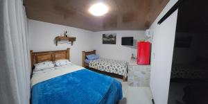a small bedroom with a blue bed and a small bedicterictericterictericter at Rio Sereno Suítes - Lumiar in Lumiar