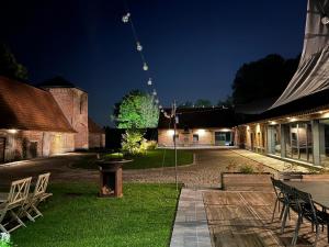 a courtyard at night with a table and chairs at Appartement T2 en pleine nature au sein d'une ferme au carré in Wambrechies